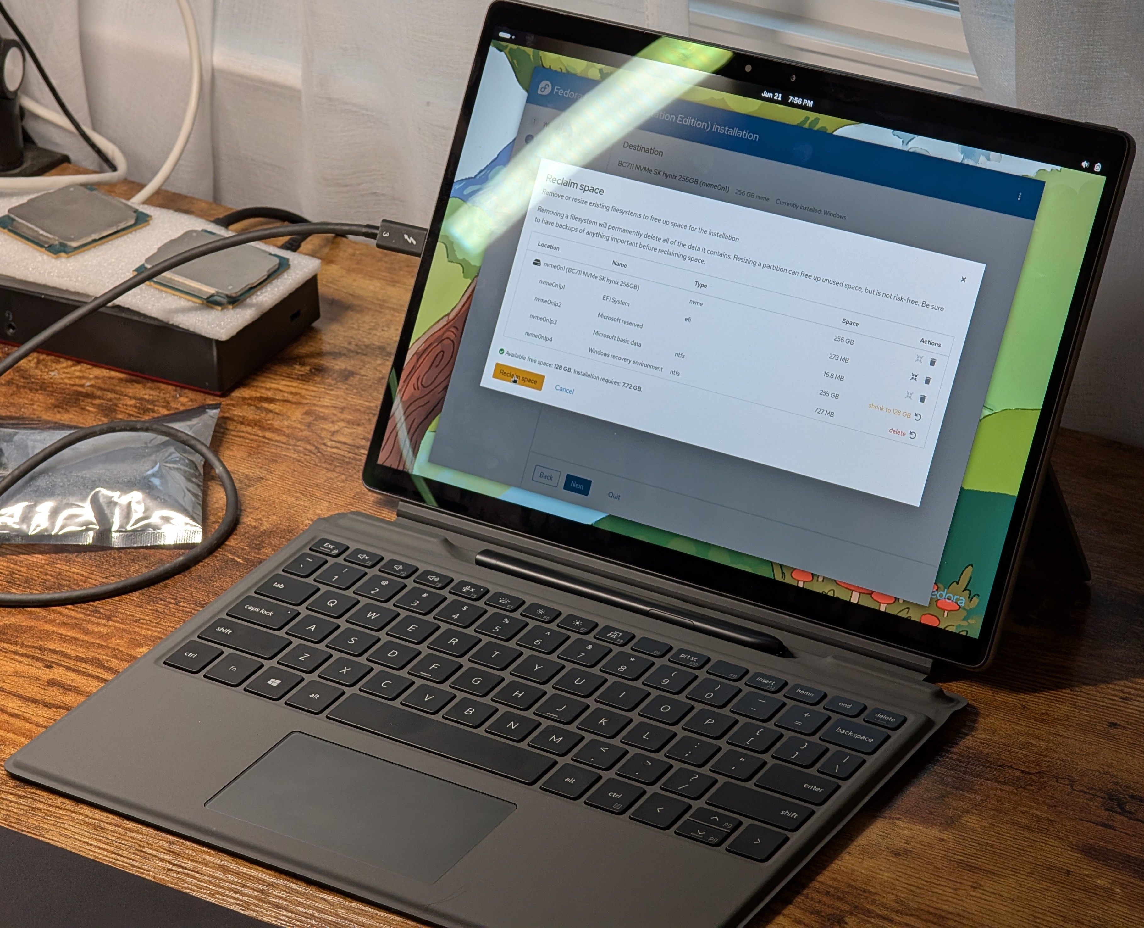 The Dell 7320 on a desk, open, displaying the Fedora Linux installer